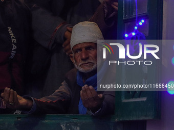 A Kashmiri Muslim man prays upon seeing a relic of Sheikh Abdul Qadir Jeelani, a Sufi saint, on his death anniversary outside his shrine in...