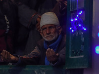 A Kashmiri Muslim man prays upon seeing a relic of Sheikh Abdul Qadir Jeelani, a Sufi saint, on his death anniversary outside his shrine in...