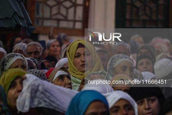 A Kashmiri Muslim woman prays upon seeing a relic of Sheikh Abdul Qadir Jeelani, a Sufi saint, on his death anniversary outside his shrine i...