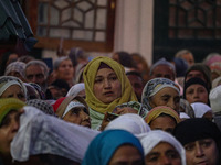 A Kashmiri Muslim woman prays upon seeing a relic of Sheikh Abdul Qadir Jeelani, a Sufi saint, on his death anniversary outside his shrine i...