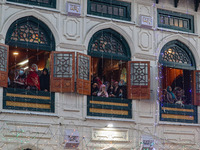 Kashmiri Muslim women raise their arms in prayer upon seeing a relic of Sheikh Abdul Qadir Jeelani, a Sufi saint, on his death anniversary o...