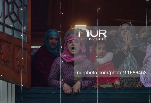 A Kashmiri Muslim woman reacts upon seeing a relic of Sheikh Abdul Qadir Jeelani, a Sufi saint, on his death anniversary outside his shrine...