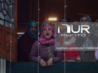 A Kashmiri Muslim woman reacts upon seeing a relic of Sheikh Abdul Qadir Jeelani, a Sufi saint, on his death anniversary outside his shrine...