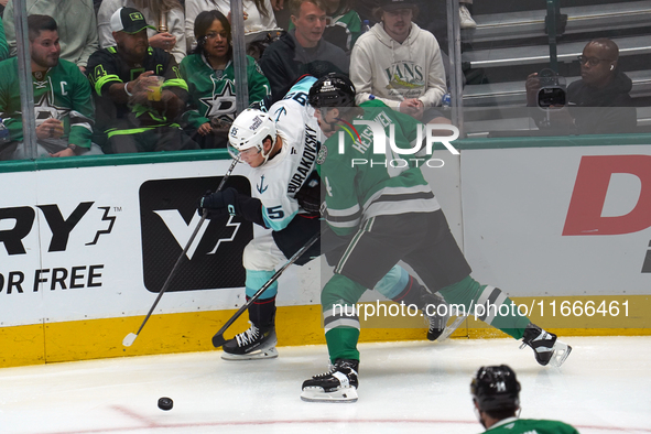 Miro Heiskanen #4 of the Dallas Stars and Andre Burakovsky #95 of the Seattle Kraken skate on the ice while battling for the puck during the...