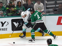 Miro Heiskanen #4 of the Dallas Stars and Andre Burakovsky #95 of the Seattle Kraken skate on the ice while battling for the puck during the...