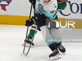 Mason Marchment #27 of the Dallas Stars and Jamie Oleksiak #24 of the Seattle Kraken skate on the ice while battling for the puck during the...