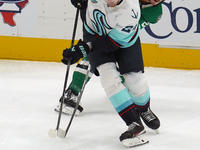 Mason Marchment #27 of the Dallas Stars and Jamie Oleksiak #24 of the Seattle Kraken skate on the ice while battling for the puck during the...