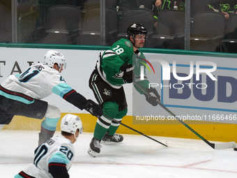 Sam Steel #18 of the Dallas Stars and Ryker Evans #41 of the Seattle Kraken skate on the ice while battling for the puck during the NHL matc...