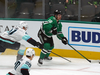 Sam Steel #18 of the Dallas Stars and Ryker Evans #41 of the Seattle Kraken skate on the ice while battling for the puck during the NHL matc...