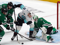 Casey DeSmith, the #1 goalkeeper of the Dallas Stars, tries to stop the shot of Carson Rehkopf, #19 of the Seattle Kraken, during the NHL ma...