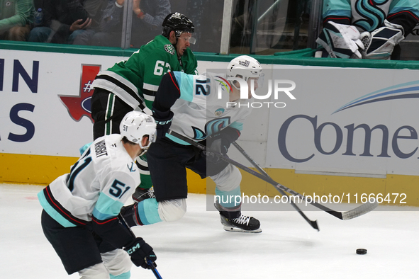 Evgenii Dadonov #63 of the Dallas Stars and Tye Kartye #12 of the Seattle Kraken skate on the ice while battling for the puck during the NHL...