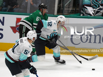 Evgenii Dadonov #63 of the Dallas Stars and Tye Kartye #12 of the Seattle Kraken skate on the ice while battling for the puck during the NHL...