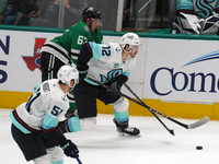 Evgenii Dadonov #63 of the Dallas Stars and Tye Kartye #12 of the Seattle Kraken skate on the ice while battling for the puck during the NHL...