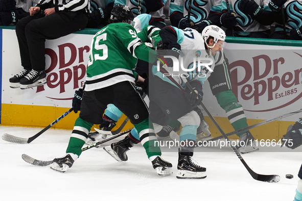 Yanni Gourde #37 of the Seattle Kraken gains possession of the puck after a battle against Dallas Stars players during the NHL match between...