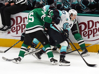 Yanni Gourde #37 of the Seattle Kraken gains possession of the puck after a battle against Dallas Stars players during the NHL match between...