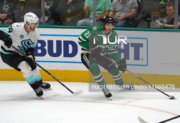 Jason Robertson #21 of the Dallas Stars and Jamie Oleksiak #24 of the Seattle Kraken skate on the ice while battling for the puck during the...