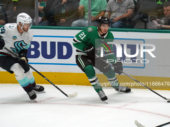 Jason Robertson #21 of the Dallas Stars and Jamie Oleksiak #24 of the Seattle Kraken skate on the ice while battling for the puck during the...