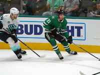 Jason Robertson #21 of the Dallas Stars and Jamie Oleksiak #24 of the Seattle Kraken skate on the ice while battling for the puck during the...