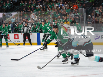 Evgenii Dadonov #63 of the Dallas Stars and Tye Kartye #12 of the Seattle Kraken skate on the ice while battling for the puck during the NHL...