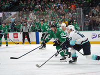 Evgenii Dadonov #63 of the Dallas Stars and Tye Kartye #12 of the Seattle Kraken skate on the ice while battling for the puck during the NHL...