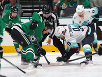 Roope Hintz #24 of the Dallas Stars and Chandler Stephenson #9 of the Seattle Kraken line up against one another during the NHL match betwee...