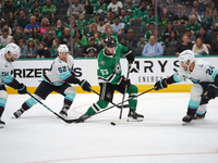 Wyatt Johnston #53 of the Dallas Stars defends the puck against Jamie Oleksiak #24 and Brandon Montour #62 of the Seattle Kraken during the...