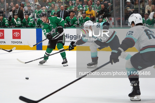 Wyatt Johnston #53 of the Dallas Stars defends the puck against Jamie Oleksiak #24 and Brandon Montour #62 of the Seattle Kraken during the...