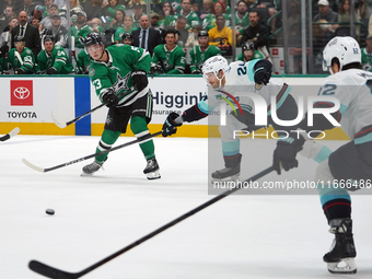 Wyatt Johnston #53 of the Dallas Stars defends the puck against Jamie Oleksiak #24 and Brandon Montour #62 of the Seattle Kraken during the...