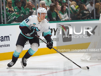 Ryker Evans #41 of the Seattle Kraken slides on the ice to control the puck during the NHL match between the Dallas Stars and the Seattle Kr...