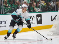 Ryker Evans #41 of the Seattle Kraken slides on the ice to control the puck during the NHL match between the Dallas Stars and the Seattle Kr...