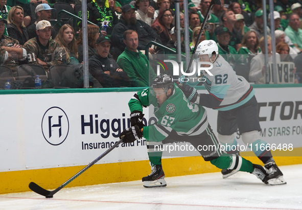 Evgenii Dadonov #63 of the Dallas Stars and Brandon Montour #62 of the Seattle Kraken skate on the ice while battling for the puck during th...