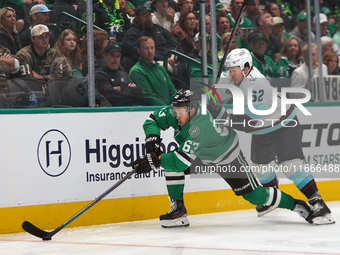 Evgenii Dadonov #63 of the Dallas Stars and Brandon Montour #62 of the Seattle Kraken skate on the ice while battling for the puck during th...