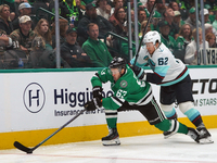 Evgenii Dadonov #63 of the Dallas Stars and Brandon Montour #62 of the Seattle Kraken skate on the ice while battling for the puck during th...