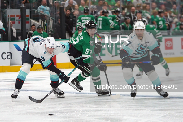 Wyatt Johnston #53 of the Dallas Stars defends the puck against Will Borgen #3 and Jordan Eberle #7 of the Seattle Kraken during the NHL mat...