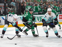 Wyatt Johnston #53 of the Dallas Stars defends the puck against Will Borgen #3 and Jordan Eberle #7 of the Seattle Kraken during the NHL mat...