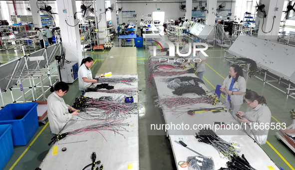 Workers produce new energy commercial vehicle parts at a workshop in Haian, Jiangsu province, China, on October 15, 2024. 