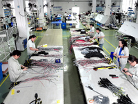 Workers produce new energy commercial vehicle parts at a workshop in Haian, Jiangsu province, China, on October 15, 2024. (