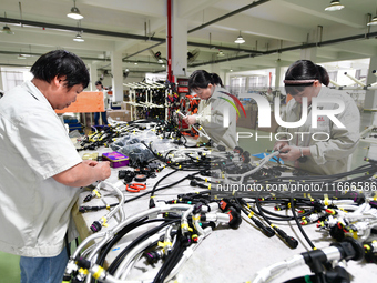 Workers produce new energy commercial vehicle parts at a workshop in Haian, Jiangsu province, China, on October 15, 2024. (