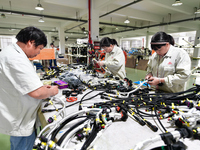 Workers produce new energy commercial vehicle parts at a workshop in Haian, Jiangsu province, China, on October 15, 2024. (