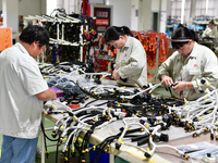 Workers produce new energy commercial vehicle parts at a workshop in Haian, Jiangsu province, China, on October 15, 2024. (