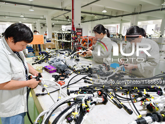 Workers produce new energy commercial vehicle parts at a workshop in Haian, Jiangsu province, China, on October 15, 2024. (