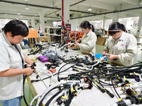 Workers produce new energy commercial vehicle parts at a workshop in Haian, Jiangsu province, China, on October 15, 2024. (