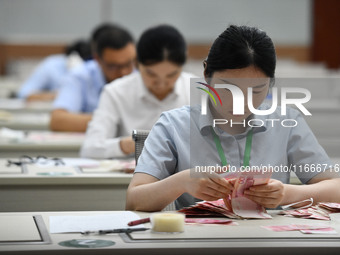 A contestant competes to identify counterfeit currency during a professional skills competition in the banking industry's currency and gold...