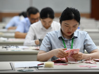 A contestant competes to identify counterfeit currency during a professional skills competition in the banking industry's currency and gold...