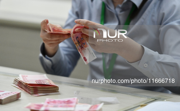 A contestant competes to identify counterfeit currency during a professional skills competition in the banking industry's currency and gold...