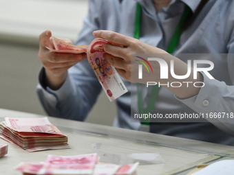 A contestant competes to identify counterfeit currency during a professional skills competition in the banking industry's currency and gold...