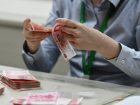 A contestant competes to identify counterfeit currency during a professional skills competition in the banking industry's currency and gold...