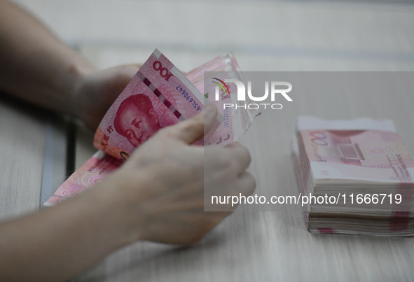 A contestant competes to identify counterfeit currency during a professional skills competition in the banking industry's currency and gold...