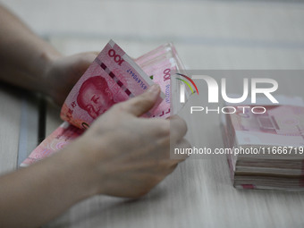 A contestant competes to identify counterfeit currency during a professional skills competition in the banking industry's currency and gold...