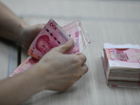 A contestant competes to identify counterfeit currency during a professional skills competition in the banking industry's currency and gold...